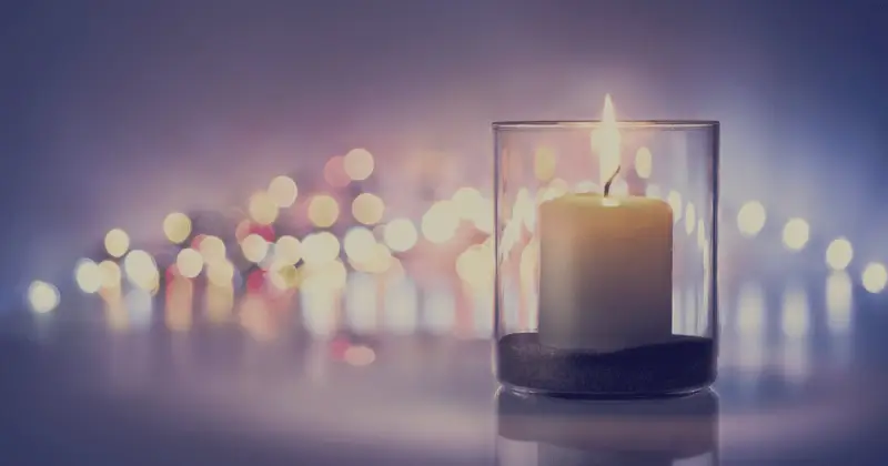 A lit candle glowing in the dark
