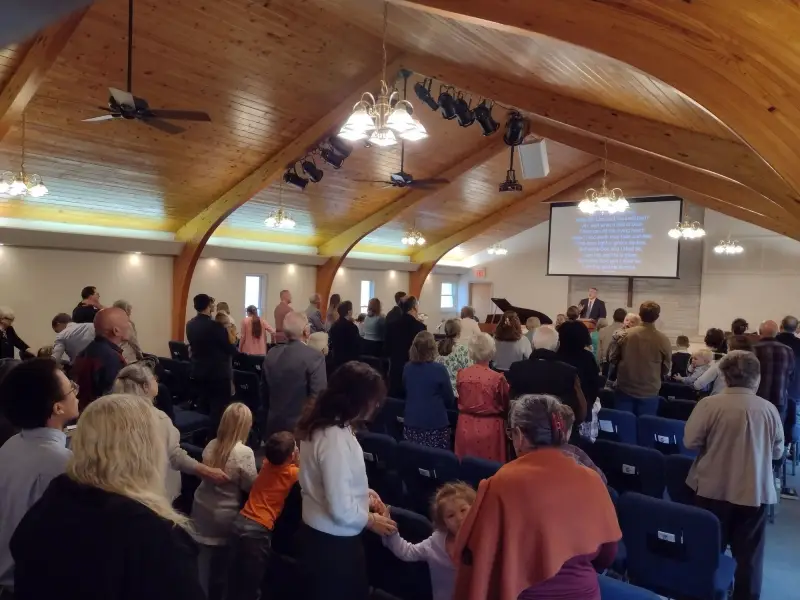 The Grace Baptist congregation standing together during Sunday worship